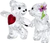 Two crystal teddy bears are shown in a romantic pose, one holding a red heart and the other offering a purple flower. Produktbild-Vorschau