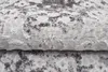 A close-up view of a folded rug with a distressed pattern. Produktbild-Vorschau