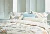 A neatly made bed with multiple decorative pillows. Produktbild-Vorschau