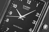 A close-up shot of a black analog watch face with white hands and numbers. Anteprima dell’immagine prodotto