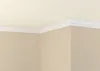 A corner of a room showing crown molding installed along the ceiling and walls. Produktbild-Vorschau