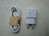 A white USB charging cable and a white USB wall adapter are laid out on a textured gray surface. Produktbild-Vorschau