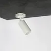 A white cylinder spotlight is attached to a dark gray ceiling. Náhľad obrázku produktu