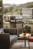 A gas grill on a balcony with a sofa and plants. Produktbild-Vorschau