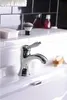 A close-up shot of a chrome and white bathroom faucet on a white sink. Podgląd zdjęcia produktu