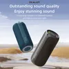 Two portable speakers are displayed in a stylized outdoor setting with water and sand dunes. Produktbild-Vorschau
