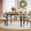 A round dining table set with chairs, flowers, and fruit, in a dining room setting with a wreath above a fireplace. Podgląd zdjęcia produktu