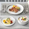 A table setting with plates of food and cutlery. Náhled obrázku produktu