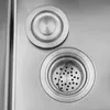 A close-up view of a stainless steel sink drain and a sink stopper. Náhled obrázku produktu