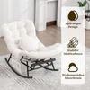 A beige rocking chair with a corduroy cover and a small round pillow is shown in a room with a fireplace in the background. Produktbild-Vorschau