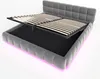 A grey upholstered bed frame with its storage compartment open, revealing the slatted base and the internal storage space. Pink LED lighting illuminates the base of the bed. Anteprima dell’immagine prodotto