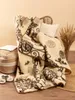 A cozy scene with a blanket draped over a chair, next to a basket and slippers. Produktbild-Vorschau
