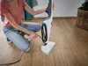 A person is plugging in a steam mop on a wooden floor. Anteprima dell’immagine prodotto