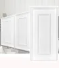 Close-up view of white cabinet doors with decorative paneling. Produktbild-Vorschau