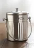 A stainless steel kitchen composter with a lid and handle, placed on a wooden surface. Náhled obrázku produktu