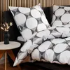 A close-up view of a bed with pillows and bedding featuring a geometric pattern. Produktbild-Vorschau