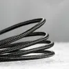A close-up shot of a coiled black braided cable. Náhľad obrázku produktu