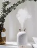 A humidifier with deer antlers is placed next to a brown glass bottle with eucalyptus leaves. Náhled obrázku produktu