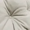 A close-up view of a tufted cushion with a stitched detail. Produktbild-Vorschau