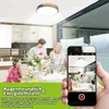 A family is having dinner in a modern kitchen, with a smartphone capturing the scene, highlighting a ceiling light. Voir les images du produit