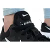A close-up shot of a person's foot wearing a black Nike Air Max shoe. Podgląd zdjęcia produktu