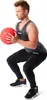 A man is performing a squat exercise with a medicine ball. Produktbild-Vorschau
