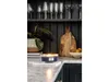 A lit candle sits on a marble countertop in a kitchen setting, with a plant and decorative items in the background. Podgląd zdjęcia produktu