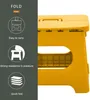 A collage of a yellow folding stool, with diagrams and text on the left side. Produktbild-Vorschau