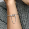 A close-up shot of a person's arm wearing a silver Pandora bracelet with charms and a safety chain. Anteprima dell’immagine prodotto