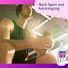 A man with headphones is sitting in a gym, holding a phone. Produktbild-Vorschau