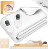 A white electric blanket folded on a mattress, with two controllers attached. A box with product information and a person lying on a bed are also visible. Produktbild-Vorschau