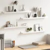 Four white floating shelves mounted on a white wall, decorated with various items. Náhľad obrázku produktu