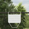 A white hanging balcony table is attached to a dark metal fence, with green trees and a cloudy sky in the background. Anteprima dell’immagine prodotto