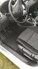 Interior view of a car, focusing on the driver's side floor mats and seat. Náhled obrázku produktu