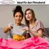 Two young women are sitting on a couch, watching TV and eating chips. Produktbild-Vorschau