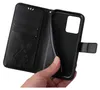 A hand holding a black flip phone case with a floral and butterfly embossed design. Produktbild-Vorschau
