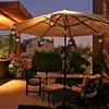 An outdoor patio at dusk with furniture and lighting. Voir les images du produit