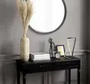 A modern LED table lamp is displayed on a black console table, alongside decorative items like a vase with dried pampas grass, books, a framed picture, an alarm clock, and a small mannequin. Náhľad obrázku produktu