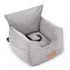 A light gray corduroy dog car seat with a black safety strap is shown against a white background. Produktbild-Vorschau
