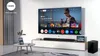 A modern living room setup with a large TV displaying a streaming service interface, a soundbar, and a subwoofer. Náhled obrázku produktu