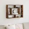 A wooden wall shelf with multiple compartments, decorated with various items, mounted on a white wall above a sofa. Náhled obrázku produktu