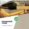 A bed frame with its storage compartment open, showing the hydraulic lift mechanism and the interior storage space. The bed is upholstered in beige fabric and has LED lighting around the base. A close-up of the fabric texture is shown in the bottom right c Produktbild-Vorschau
