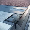 Close-up view of a roof edge detail, showing a drainage profile and gravel covering. Produktbild-Vorschau