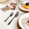 A table setting with plates, forks, and decorative cards. Produktbild-Vorschau