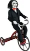 A doll of Billy the Puppet from the Saw movies riding a red tricycle. Produktbild-Vorschau