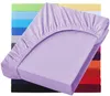 A lavender fitted sheet is shown draped over a mattress, with a stack of similarly colored sheets in the background. Produktbild-Vorschau
