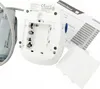 The back of a white Omron blood pressure monitor is shown, with the battery compartment open and an instruction manual nearby. Náhľad obrázku produktu