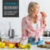 A woman is drinking a smoothie in a kitchen, with a food chopper and fruits on the counter. Produktbild-Vorschau
