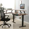 An L-shaped standing desk with a computer, printer, and headphones. Produktbild-Vorschau