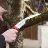 A person is using a pruning saw to cut a branch of a tree. Produktbild-Vorschau